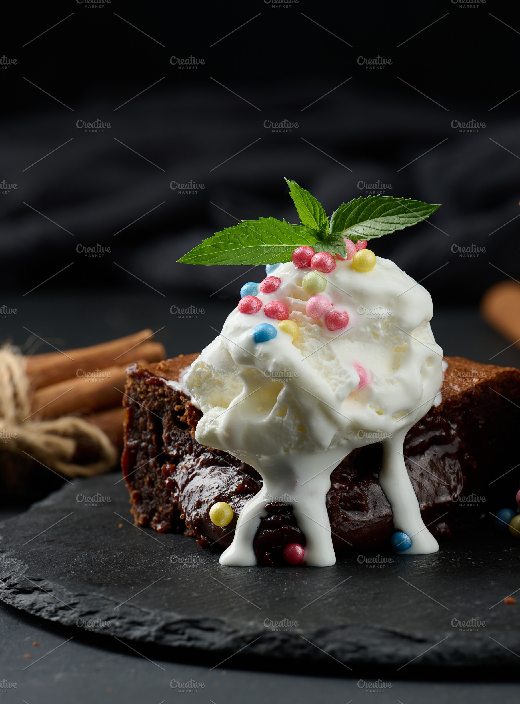 Baked pieces of chocolate brownie pie on a black table, a Food & Drink Photo by ndanko