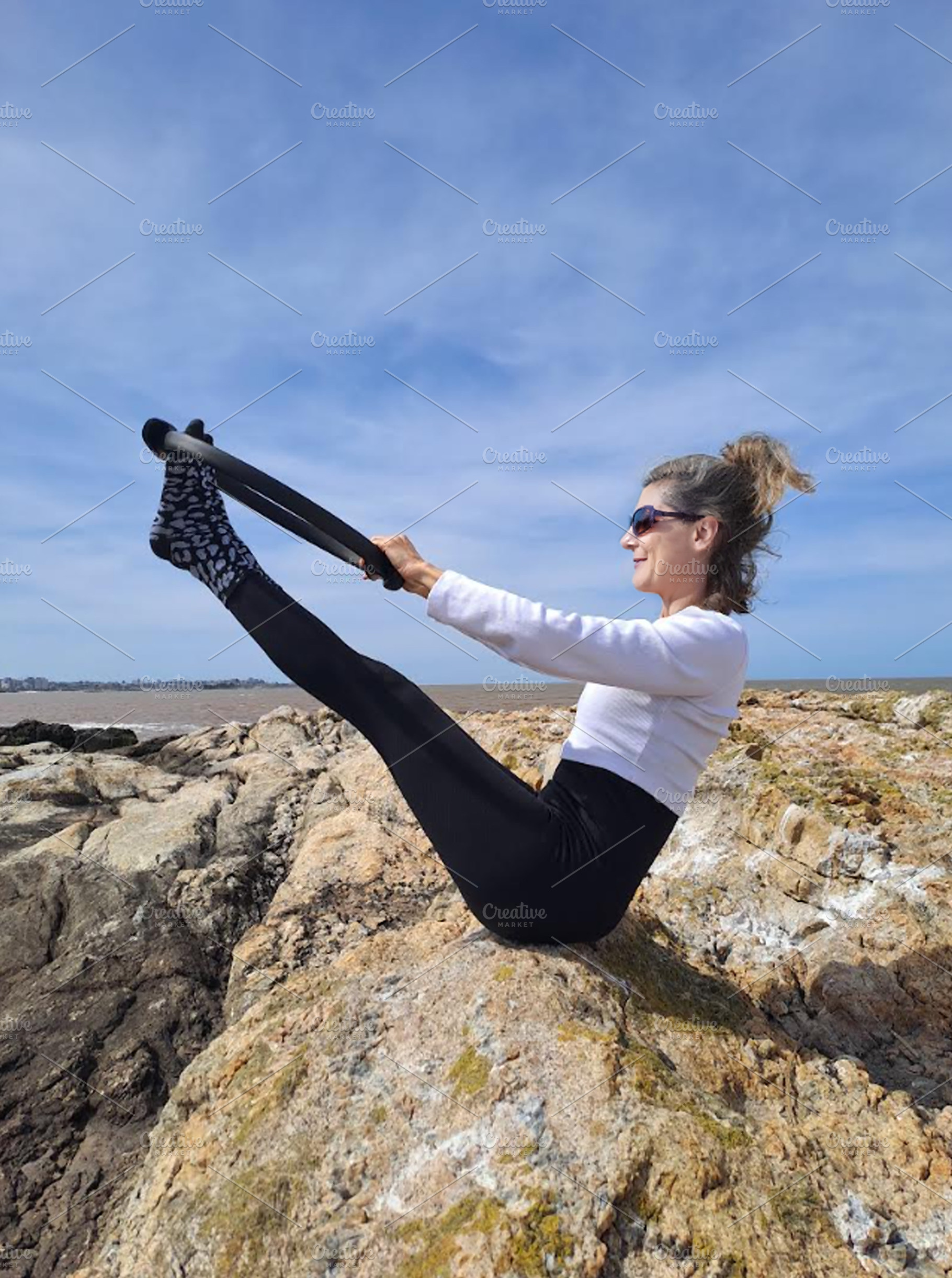 Woman practices pilates on a rugged rocky surface, a Sports & Recreation Photo by DanFLCreativo