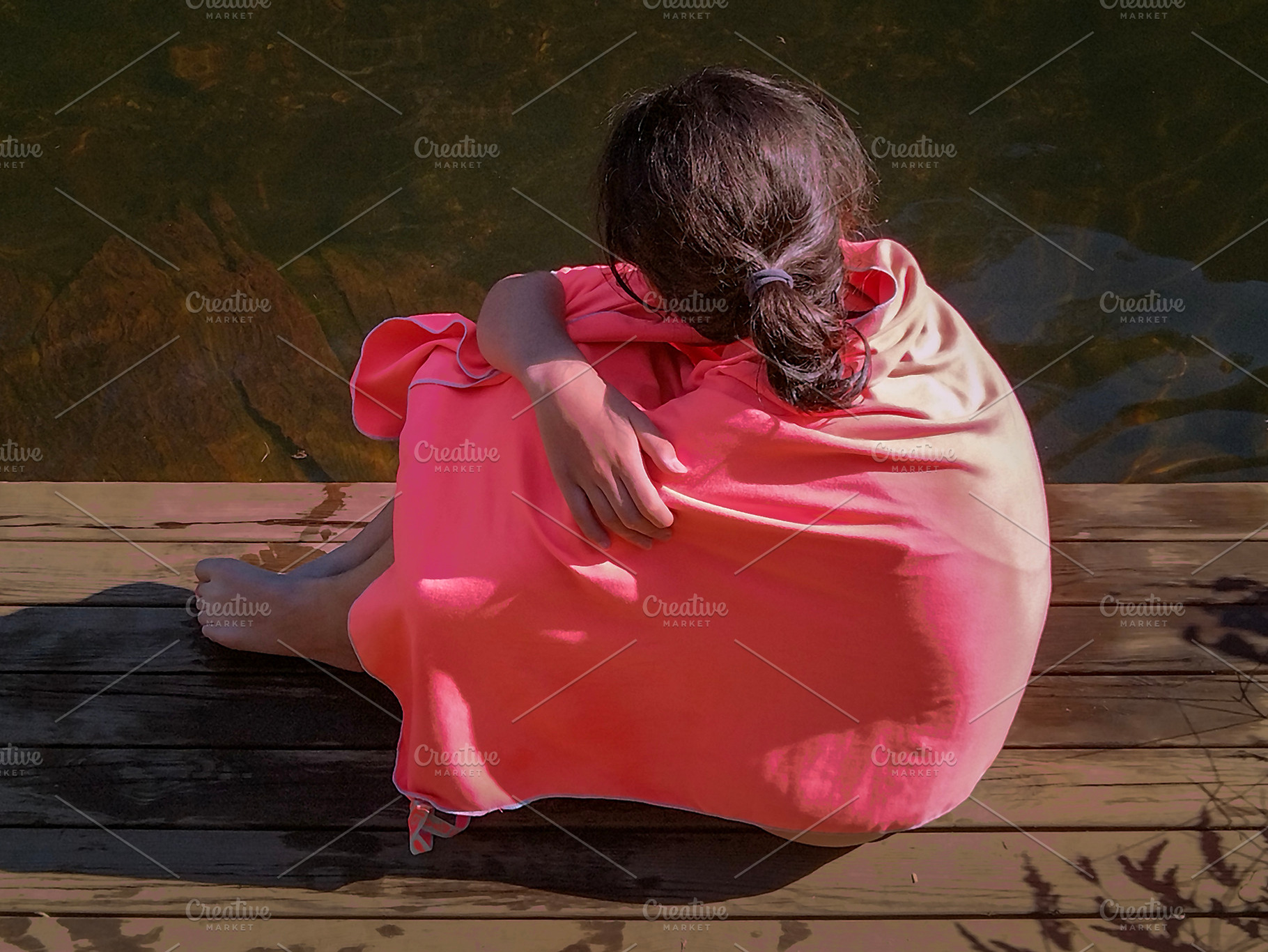 Teen woman wrapped in a blanket at border of river, a Person Photo by DanFLCreativo