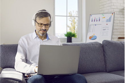 Mature man in headphones sitting on, a Technology Photo by StudioRomantic