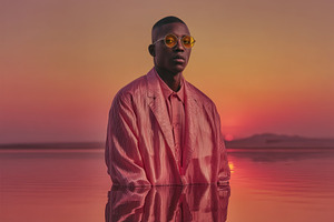 Stylish African Male Model in Pink Suit Standing in Reflective L, a Person Photo by José Manuel Gelpi