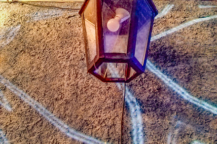 A lantern hanging on a wall, illuminated by soft light, an Architecture Photo by DanFLCreativo