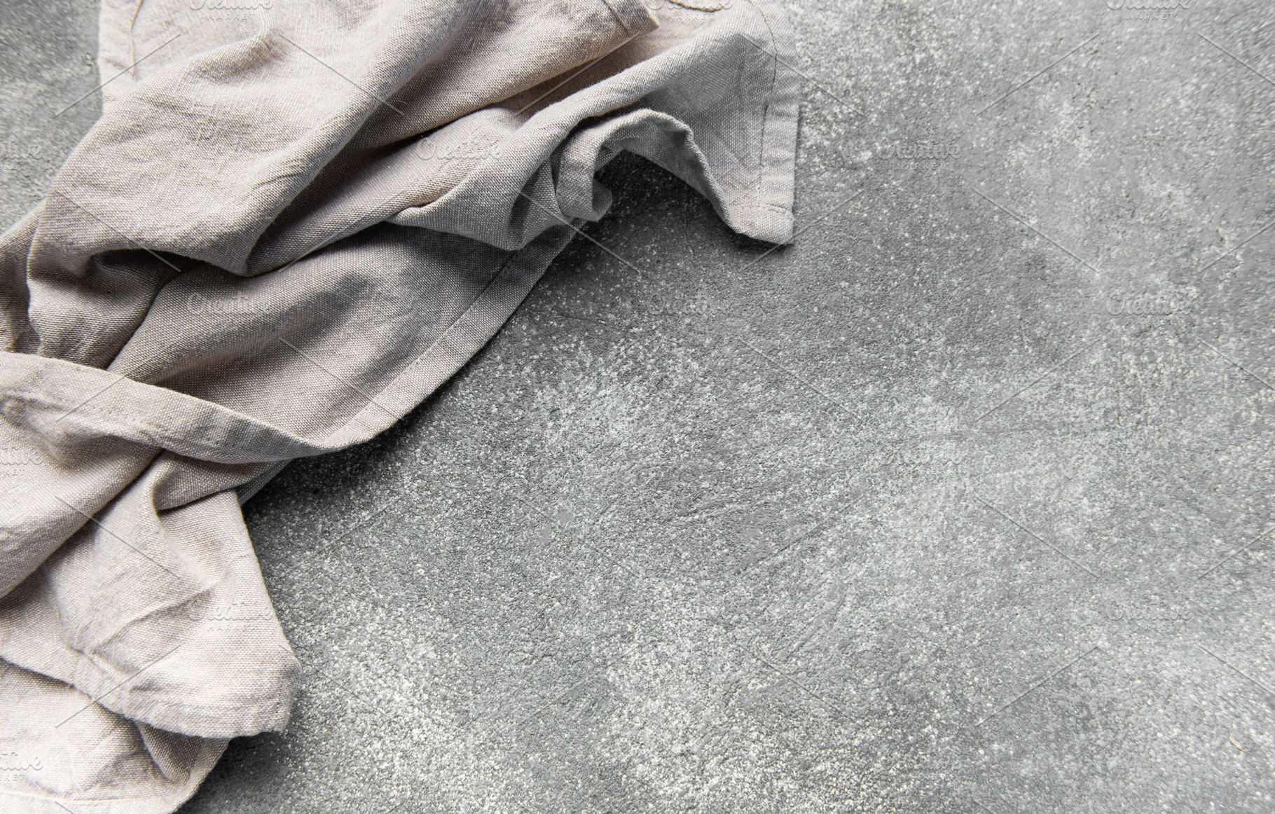 Crumpled linen napkin on rustic gray stone surface, a Food & Drink Photo by Olena Rudo