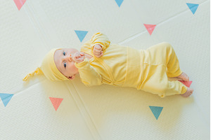 Adorable baby in a yellow hat lying, a Person Photo by Elizaveta Galitskaya