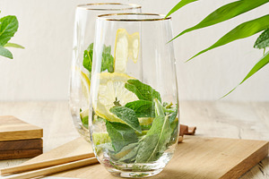 Preparing a refreshing drink. Two glasses filled with fresh lemo, a Food & Drink Photo by ndanko