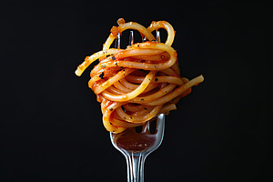 Spaghetti rolled on a fork on black background, a Food & Drink Photo by AlyaAnd