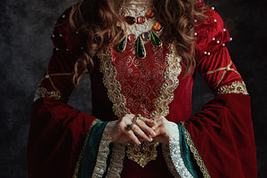 medieval queen in red dress with white makeup and crown, a Person Photo by Alliance Images
