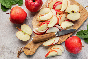 Red apples slicing on wooden cutting board, a Food & Drink Photo by Olena Rudo