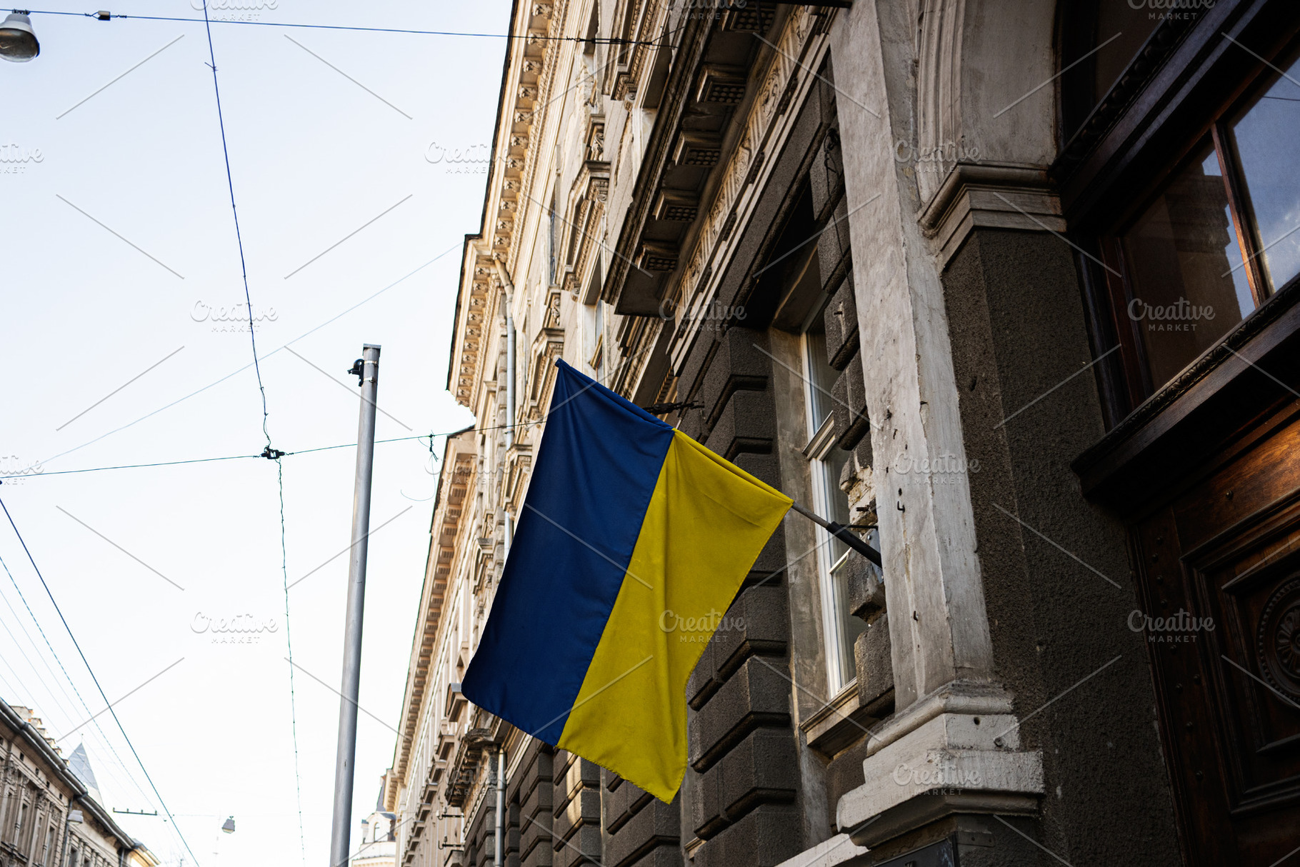 Ukrainian flag waving on a building in Lviv city on a clear day, a Photo by AS photostudio