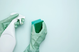 House cleaning. Womans hand in rubber glove holds green dishwashing sponge and, a Photo by matucha