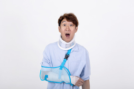 Asian man with broken arm and neck feeling surprised and shocked