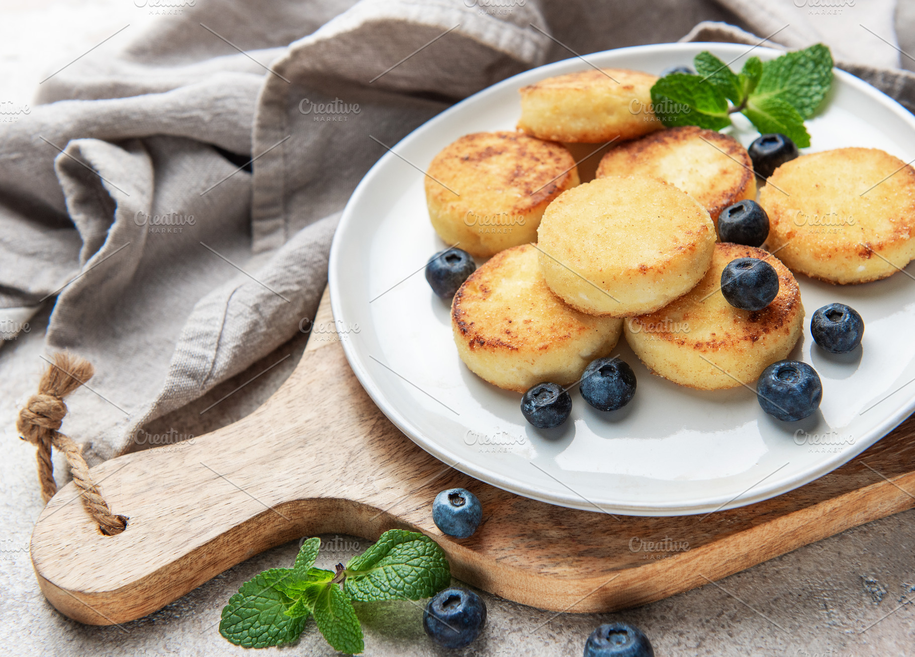 Syrniki cottage cheese pancakes with blueberries and mint, a Food & Drink Photo by Olena Rudo