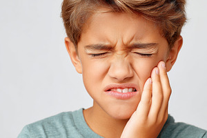 Young child making a disgusted face because of a toothache, a Health & Medical Photo by AlyaAnd