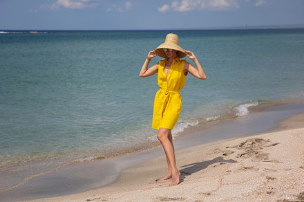 young fashionable woman in a yellow hat dress and sun glasses is posing on beac, a Person Photo by SaulichPhoto