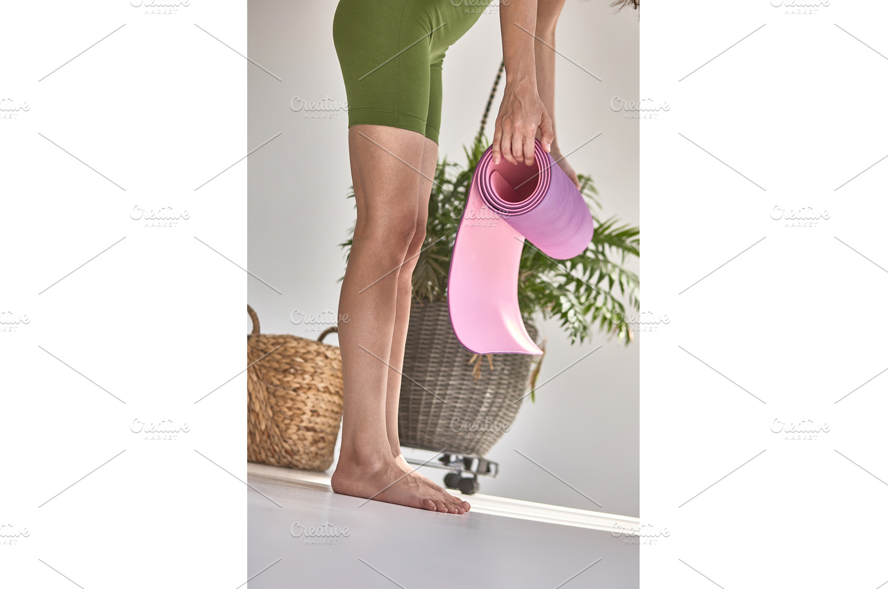 Woman unrolling pink yoga mat on, a Person Photo by wip3out
