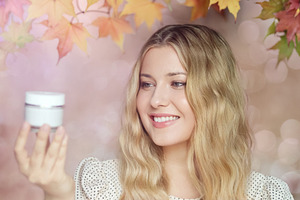 Young woman enjoying autumn skin care, smiling and holding a cos, a Person Photo by Studio ANNA