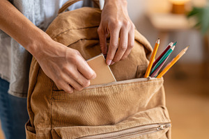 Packing notebook into tan backpack, a Holiday Photo by AlyaAnd