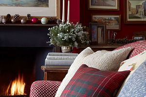 Cozy living room with festive Christmas decor, a lit fireplace, and warm pillow, a Holiday Photo by Studio ANNA