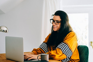 Smiling woman in her home office, a Person Photo by hitdelight
