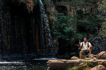 Man exploring nature by waterfall, a Person Photo by Perpis
