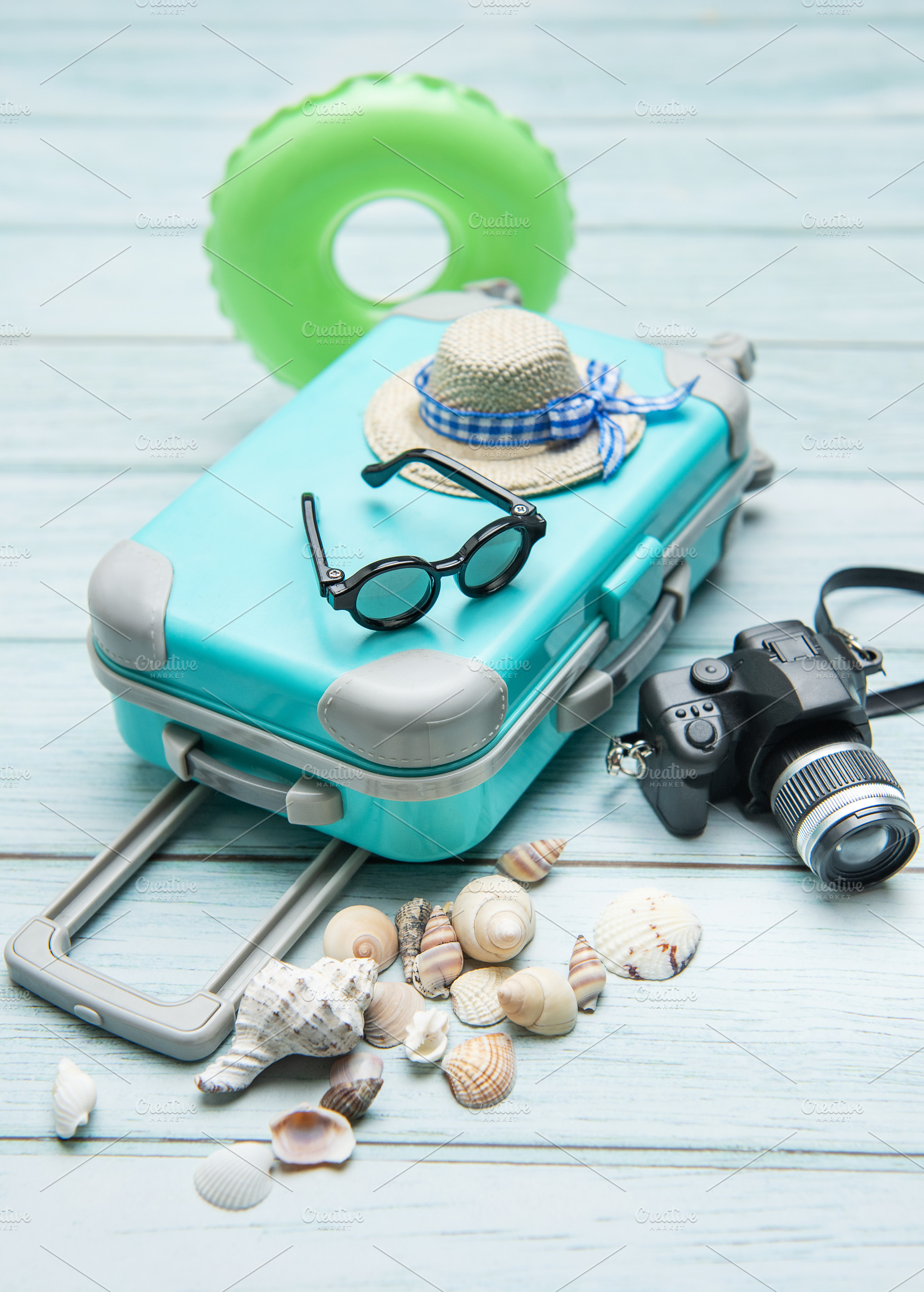 Turquoise suitcase, sunglasses, straw hat, inflatable ring, came, a Holiday Photo by Olena Rudo