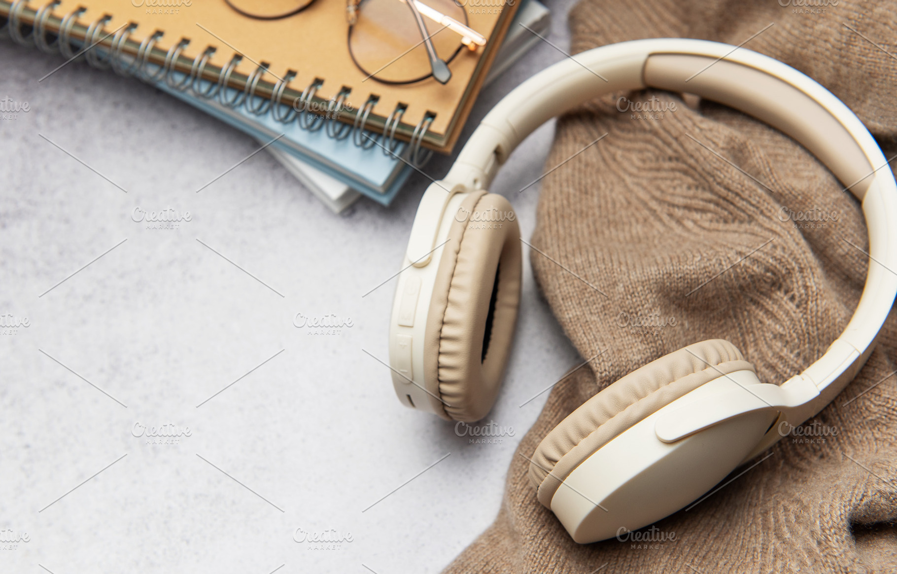 Wireless headphones, eyeglasses and notebooks resting on cozy sw, a Business Photo by Olena Rudo