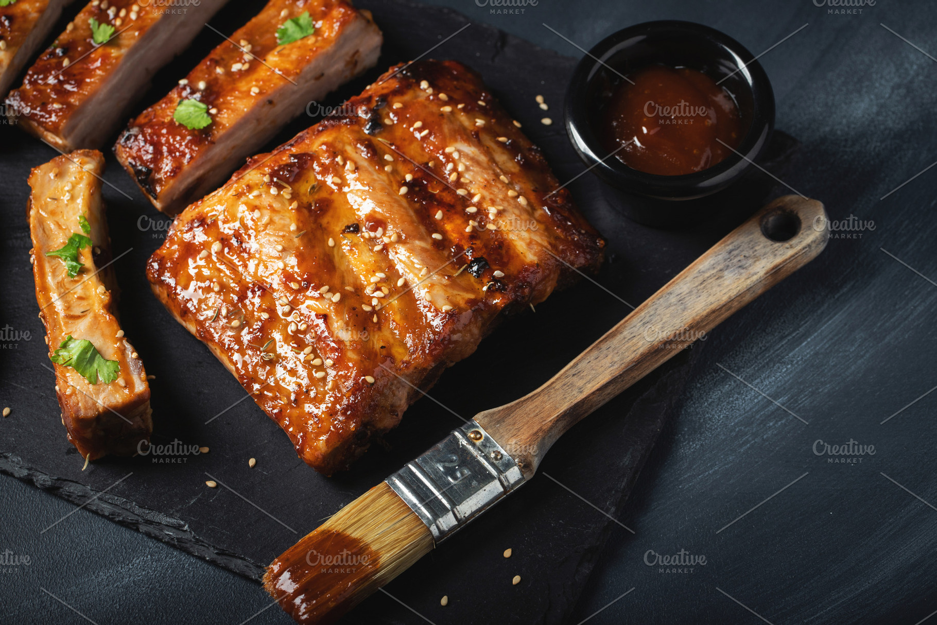 Barbecue pork spare ribs with hot honey chili marinade on black background, a Food & Drink Photo by Budarinphoto