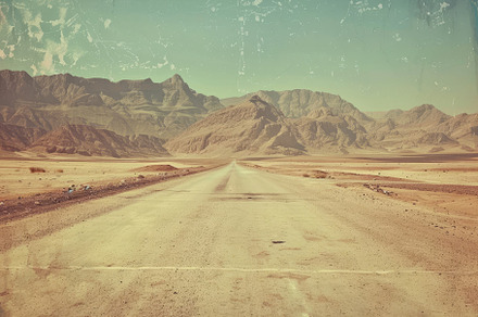A long dirt road extends through ari, a Photo by Tanuart