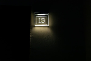 Glowing number 15 lightbox mounted on a dark wall, minimal modern style, perfec, an Abstract Photo by Ales Munt