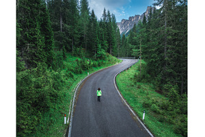 Woman walking on a winding road in, a Transportation Photo by den-belitsky