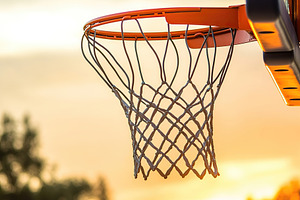 Basketball hoop illuminated by sunset, capturing the essence of evening sports, a Photo by AlyaAnd