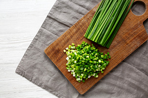 Organic Cut Green Onion Scallions on a Wooden Board, top view., a Food & Drink Photo by LiudmylaChuhunova