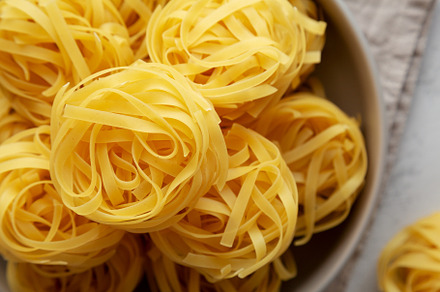 Raw Dry Tagliatelle Pasta in a Bowl, top view. Flat lay, overhea, a Food & Drink Photo by LiudmylaChuhunova