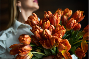 Vibrant orange tulips held by woman, a Nature Photo by wip3out