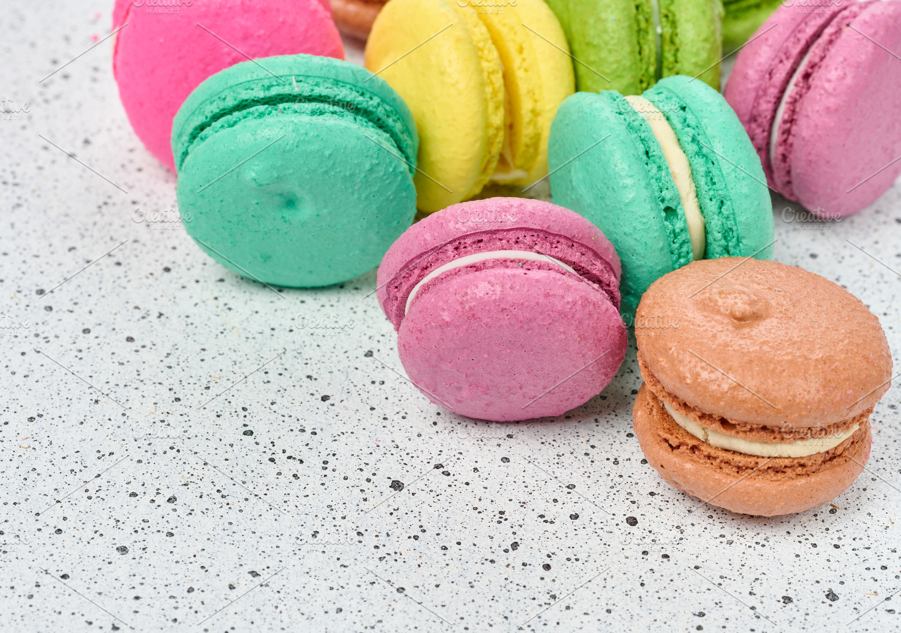 Assortment of colorful macarons in pink, green, yellow, and oran, a Food & Drink Photo by ndanko