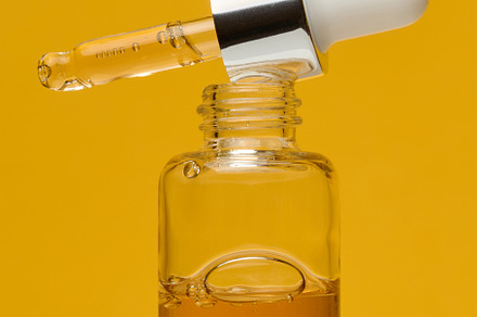 A clear glass dropper bottle with a silver cap and a white dropp