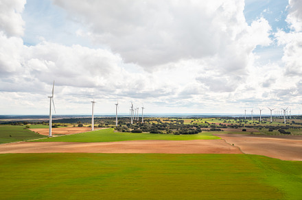 Vast solar and wind energy farm under bright cloudy sky