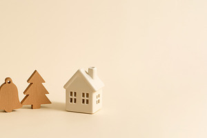 Wooden holiday symbols heart, bell, tree, and house on beige bac, a Photo by Dvoevnore photos