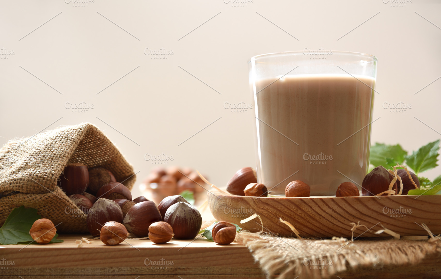 Glass of hazelnut milk on wooden plate and isolated background, a Food & Drink Photo by Davizro's Market
