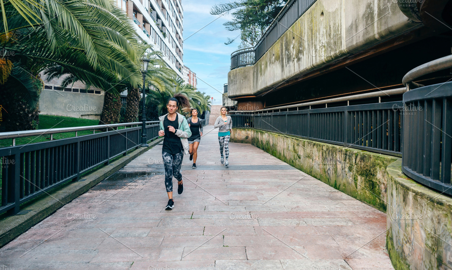 Women runners training over urban runway with palm trees, a Sports & Recreation Photo by davidpereiras