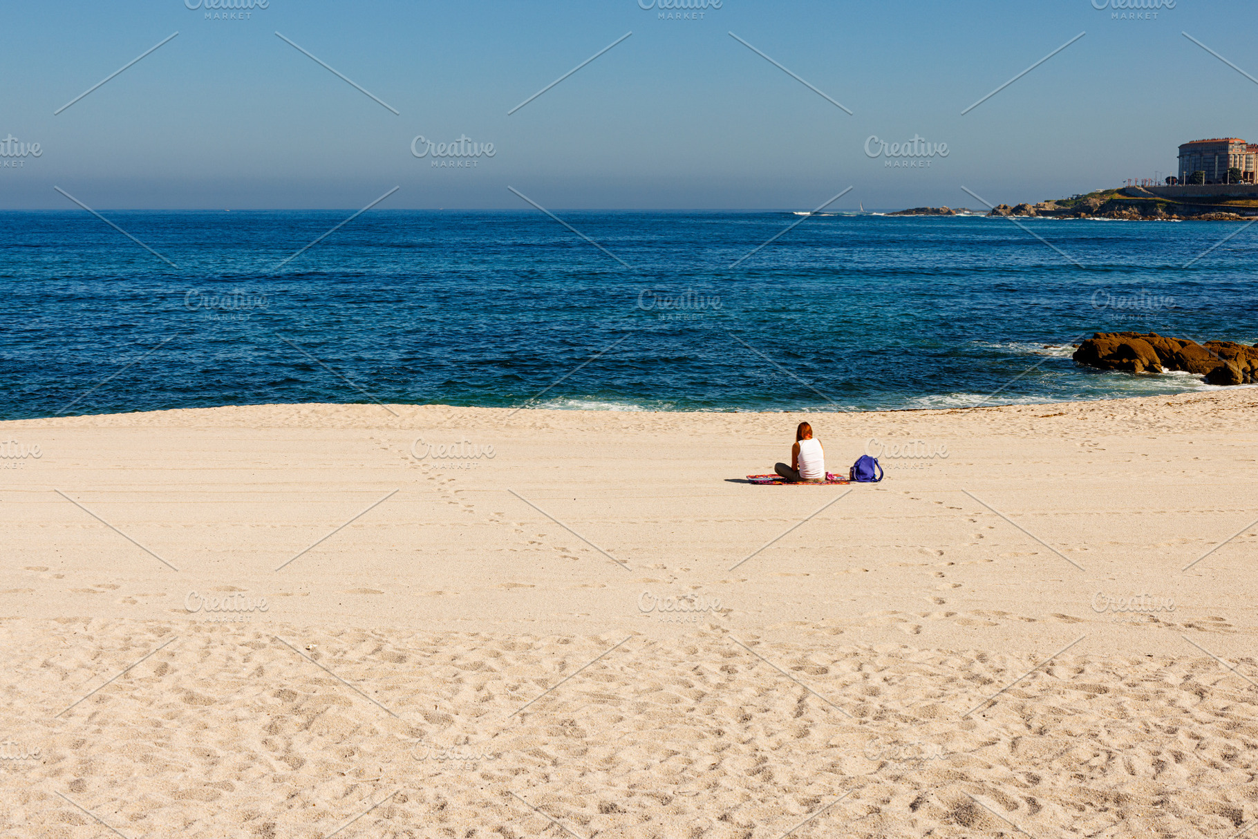 Rear view of a woman relaxing on a sandy beach in La Coruña dur, a Person Photo by Bepslabor