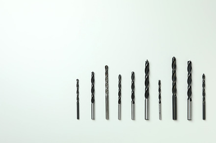Set of drills on white background, close up, an Industrial Photo by AtlasStudio PRO