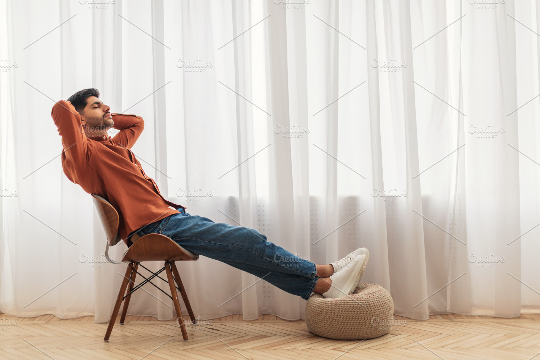 Arab man having rest at home on the couch, a Photo by Prostock-Studio