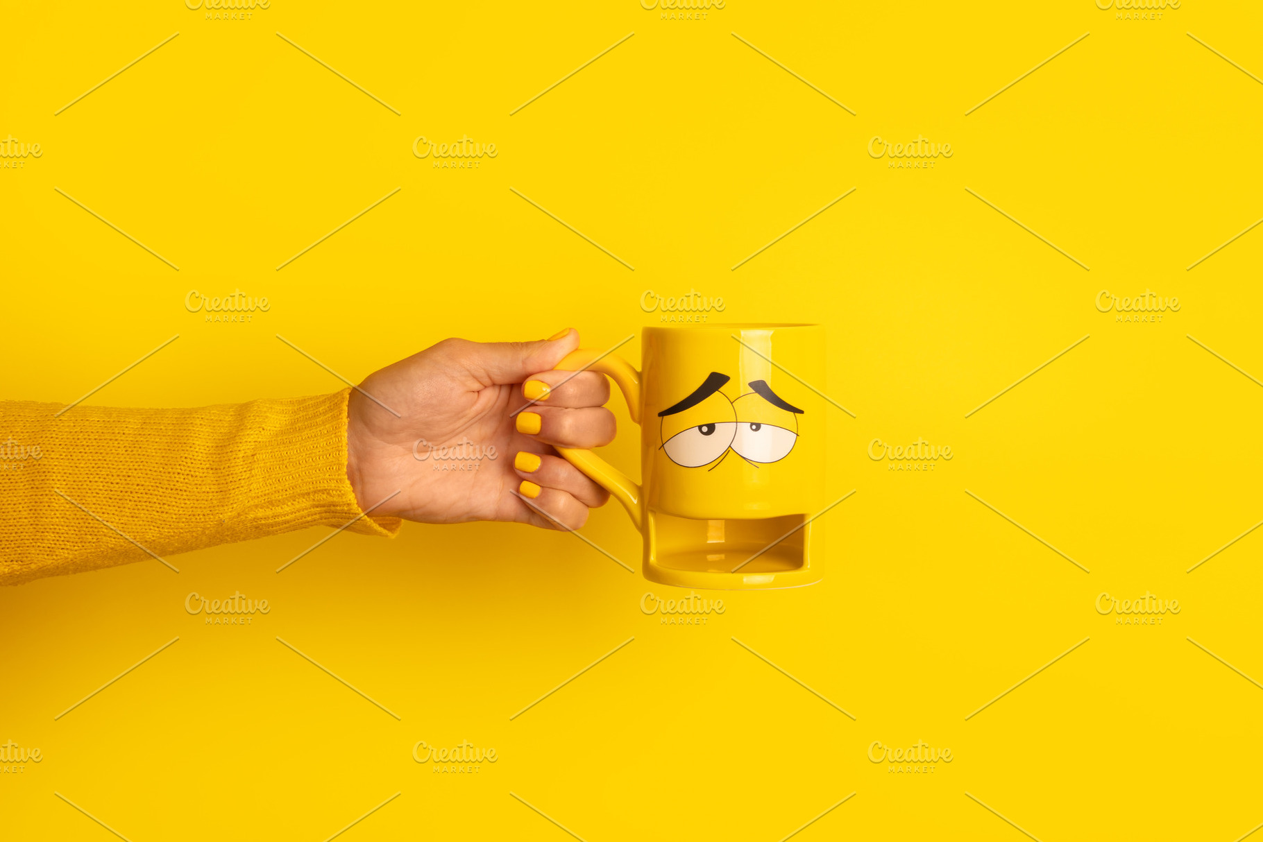 Hand in yellow sweater holding a yellow mug with a sleepy cartoo, a Food & Drink Photo by Ales Munt