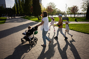 Family enjoying a sunny walk in the park with children and stroller, a Person Photo by AS photostudio