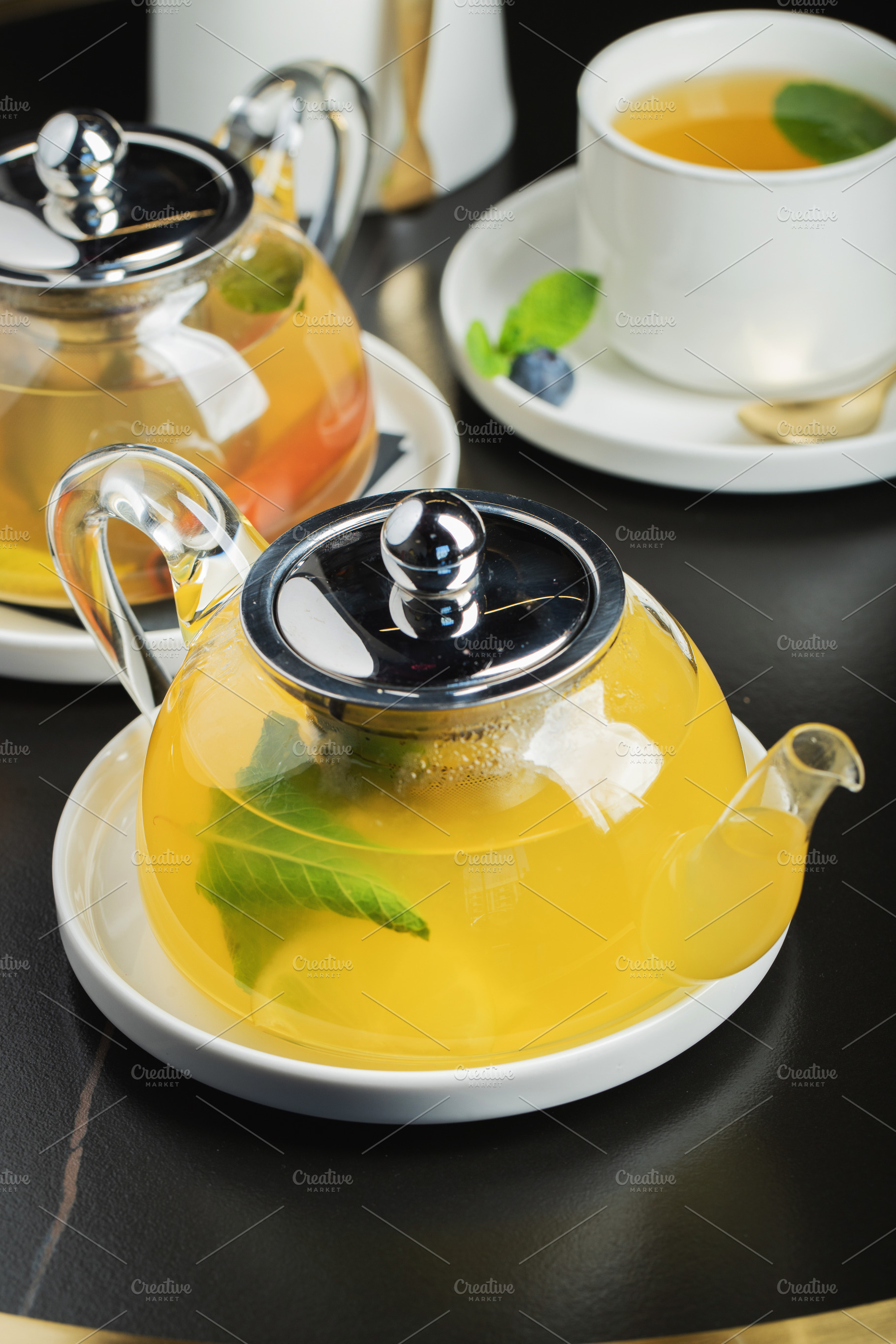 Fruit tea with mango and mint in a glass teapot on the table, a Food & Drink Photo by Budarinphoto