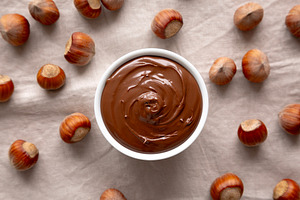 Homemade Chocolate Hazelnut Spread in a Bowl, top view., a Food & Drink Photo by LiudmylaChuhunova
