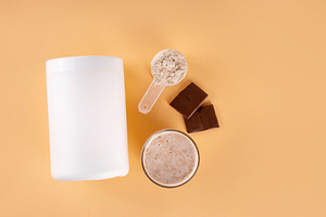 Chocolate collagen powder and drink on beige background, a Food & Drink Photo by Rimma
