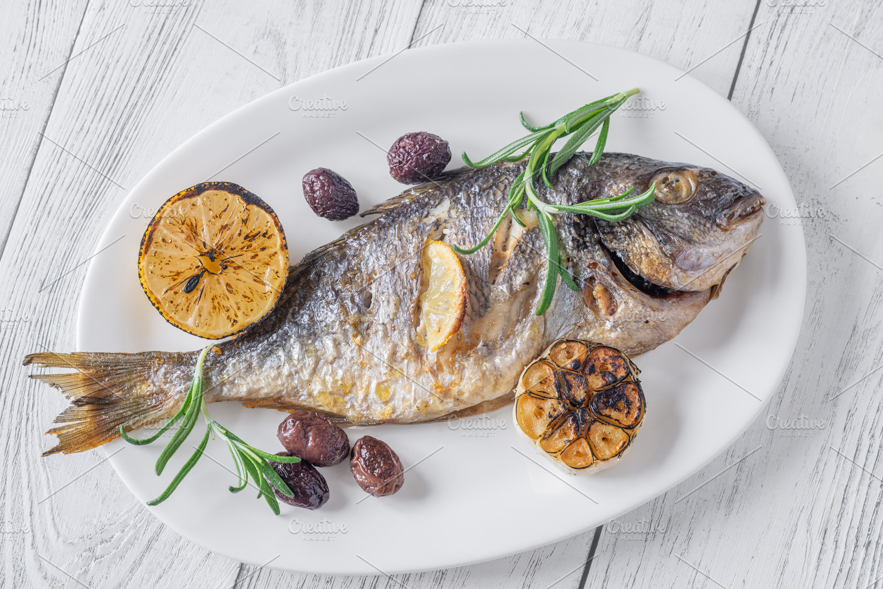 Whole roasted sea bream with lemon rosemary olives and carameliz, a Food & Drink Photo by Alexander Prokopenko