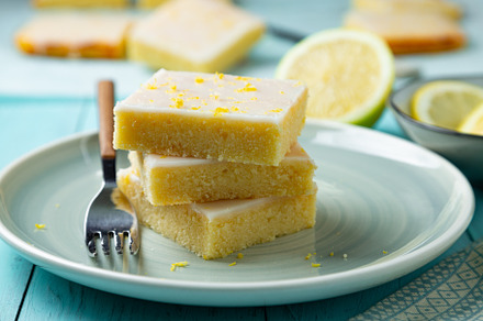 Stack of fresh lemon brownies on an aquamarine dish